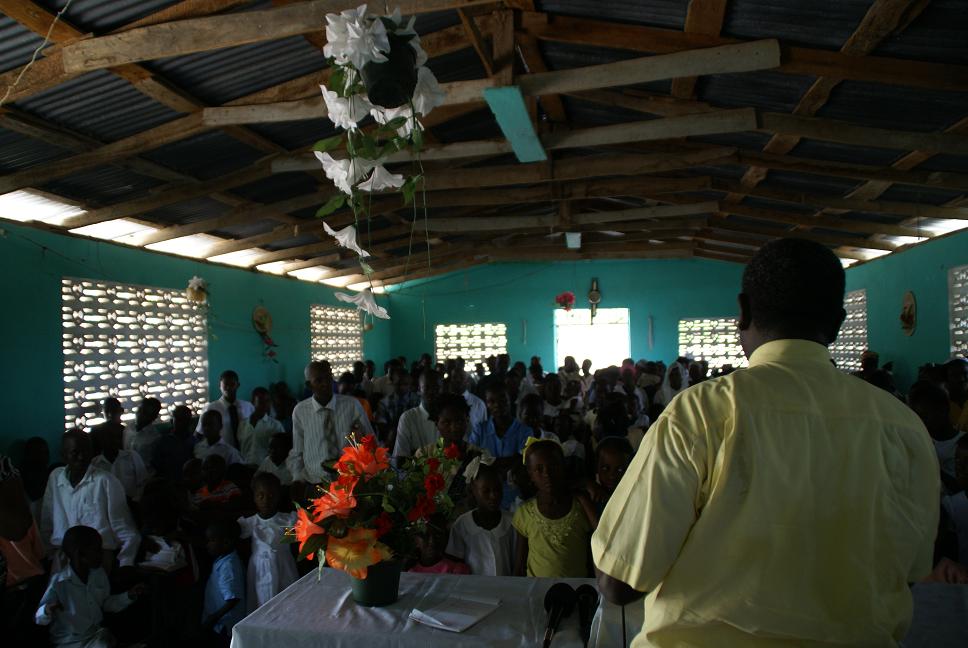 Pastor Delamy leading the congregation in worship